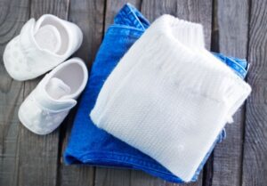 A pair of shoes and a towel on top of a wooden table.